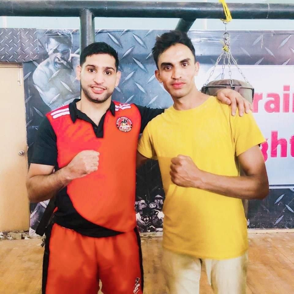 Coach with a visiting professional boxer at the gym